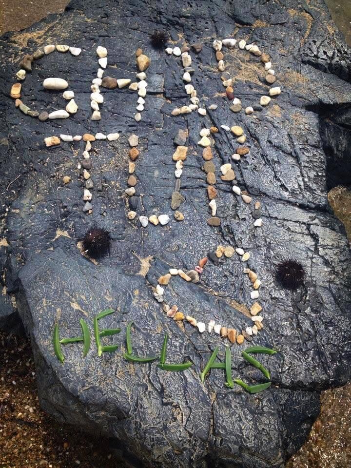 „GhidTur Hellas” și o inimă, aranjate pe o stâncă.