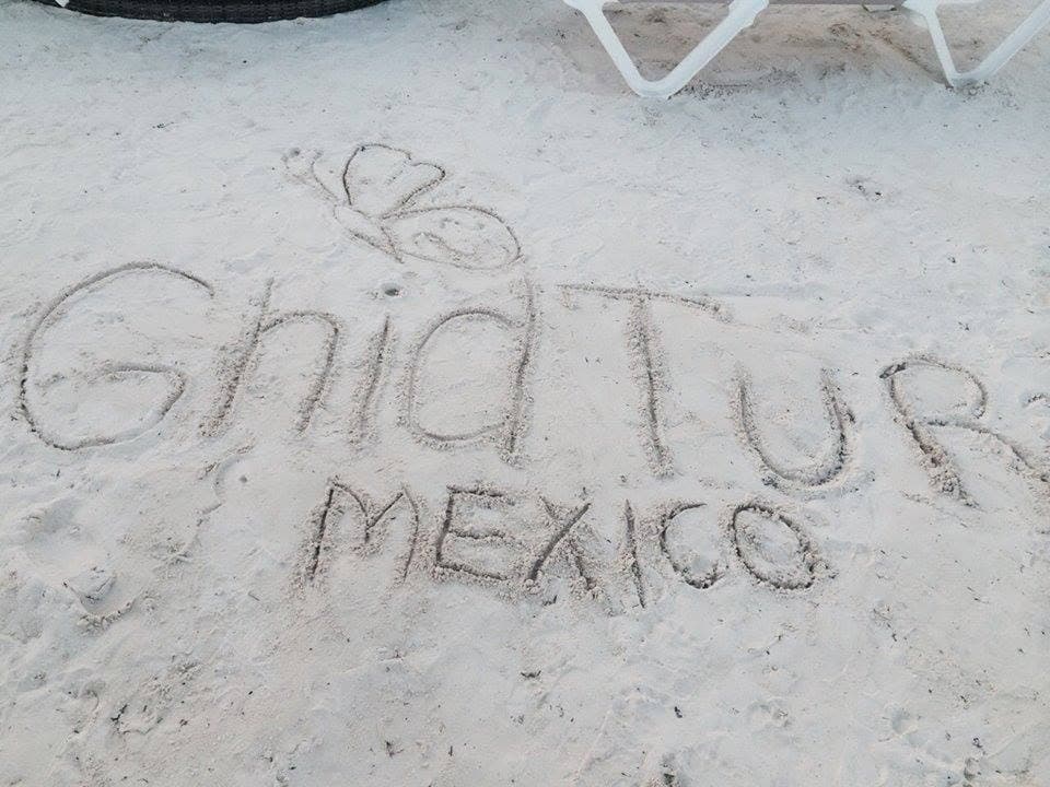 „GhidTur Mexico” și un fluture desenate pe nisip.