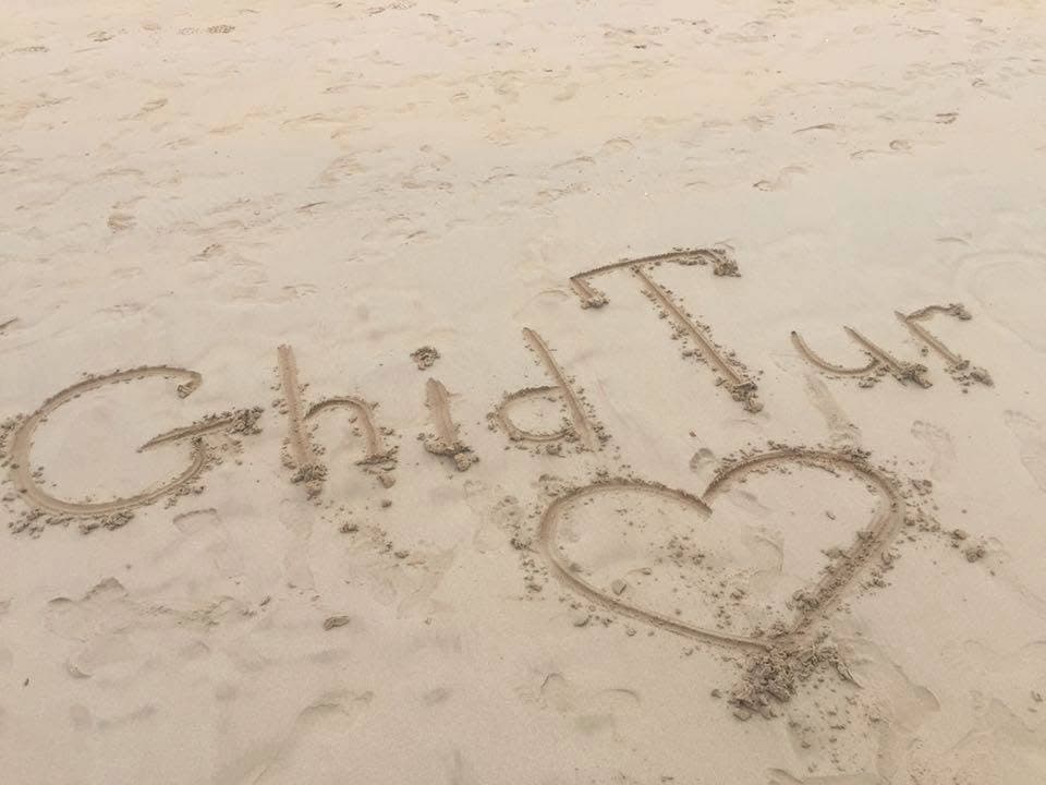 GhidTur cu drag — un mesaj pe nisip, văzut de aproape.